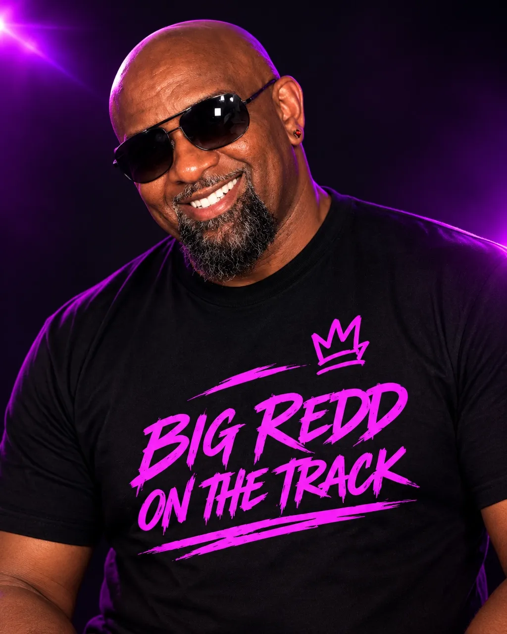DJ Big Redd on the Track, Randy Edmunds, in a branded black t-shirt for mature audiences and corporate events, against purple stage lighting
